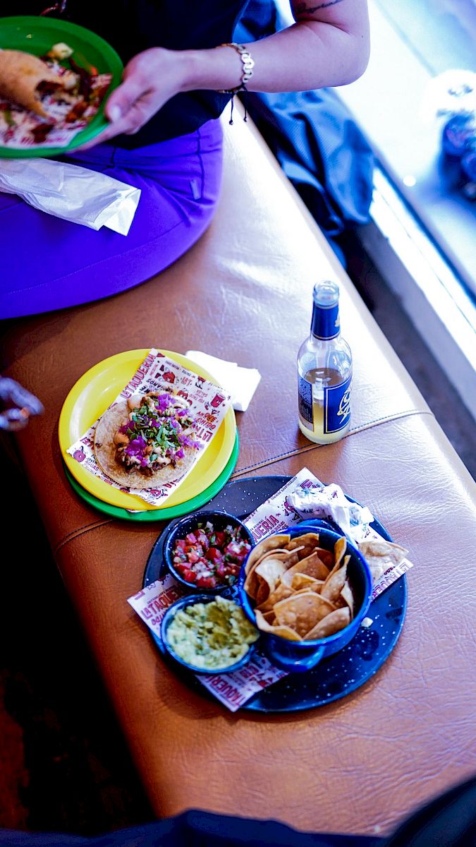 Taco, chips, salsa, and a drink on a table in a casual dining setting.